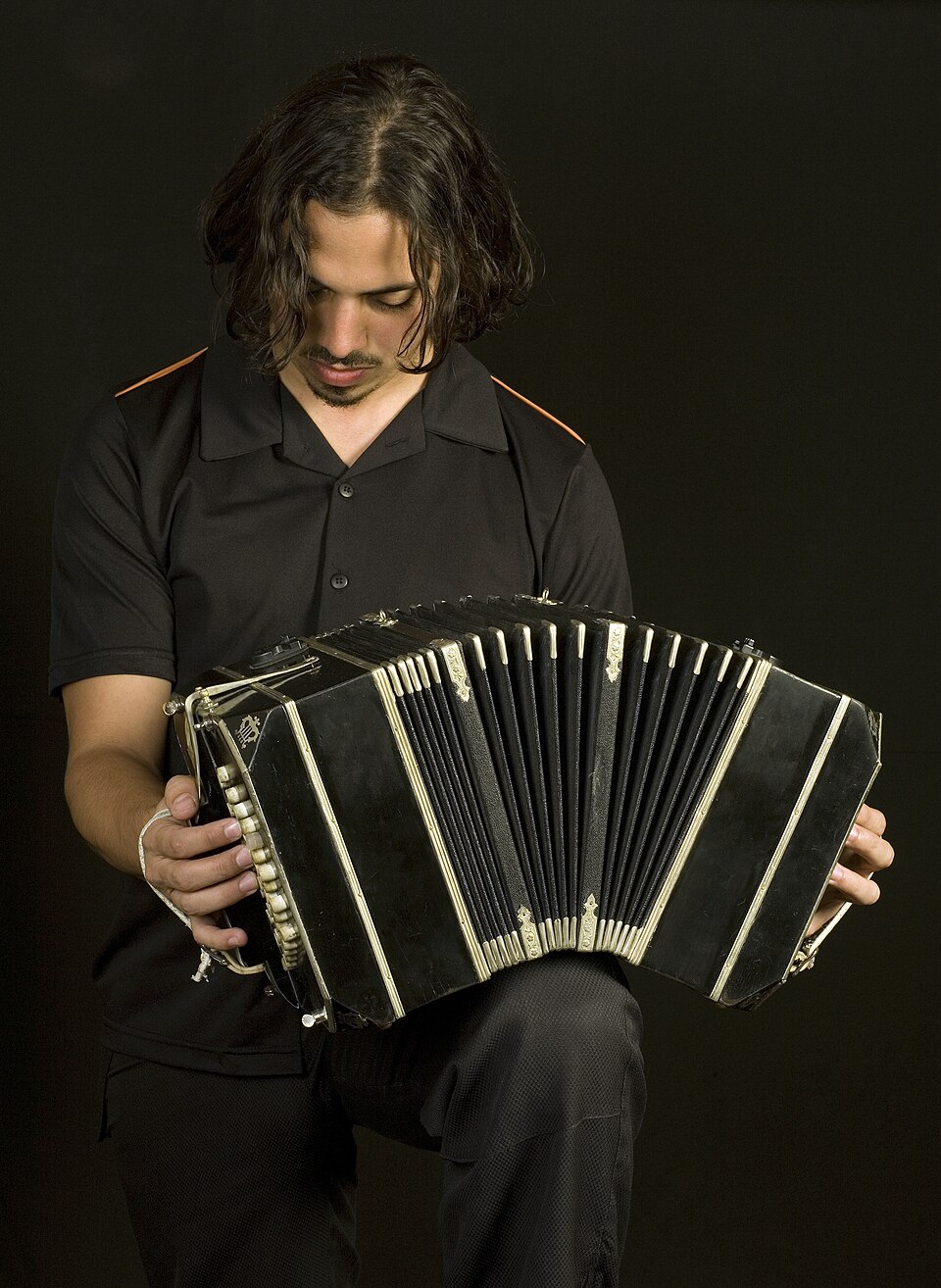 Bandoneon player Matías Rubino sits with the bellows of his instrument open in Buenos Aires.